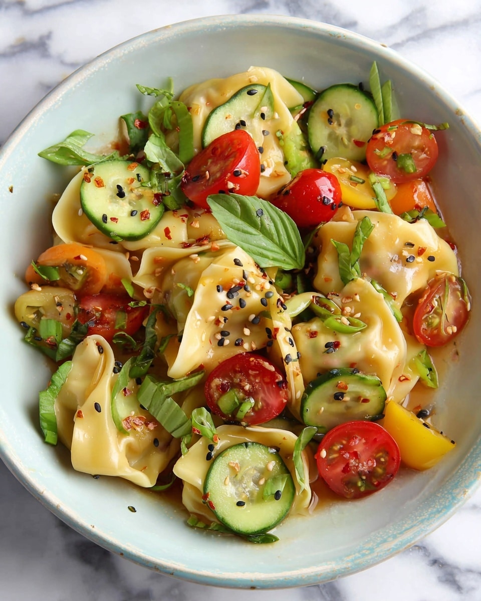 The dish shows a white bowl filled with several large, folded yellow wontons that have a smooth, slightly shiny texture. Mixed in and on top are sliced green cucumbers with a fresh, crisp look, halved red and yellow cherry tomatoes that add bright pops of color, and fresh green basil leaves. There are small black sesame seeds sprinkled across the dish along with thin slices of green onions and tiny bits of chili flakes, adding texture and a hint of spice. Everything rests lightly coated in a glossy sauce, making the ingredients look fresh and vibrant against the white bowl and white marbled surface. Photo taken with an iphone --ar 4:5 --v 7
