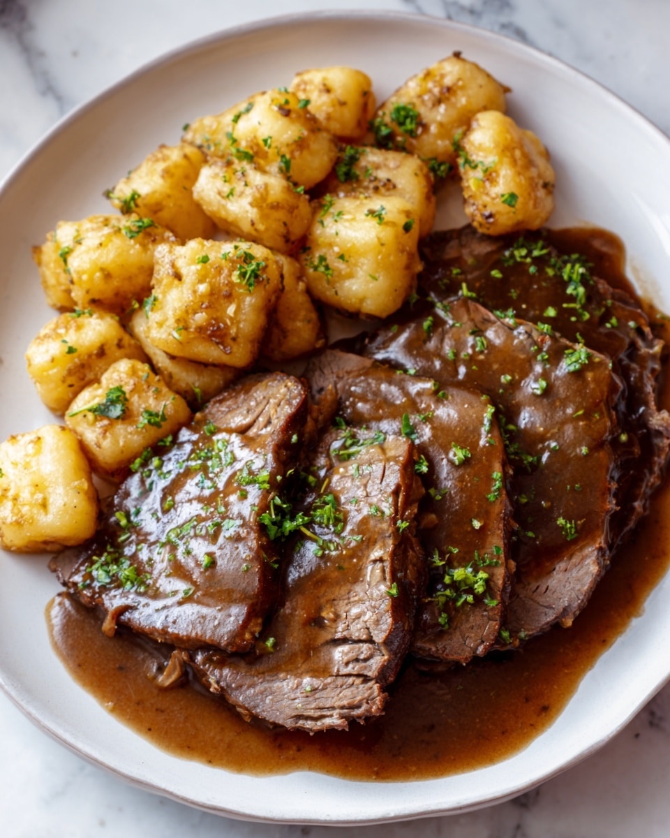 A white plate placed on a white marbled surface holds a meal with two main parts: sautéd, golden-brown gnocchi pieces arranged at the upper left side, looking soft and slightly crispy, sprinkled with finely chopped green herbs; and several thick slices of brown roast beef with a rich, glossy brown gravy poured over them and pooling around the plate’s base, garnished with chopped green herbs, creating a warm, hearty visual. Photo taken with an iphone --ar 4:5 --v 7
