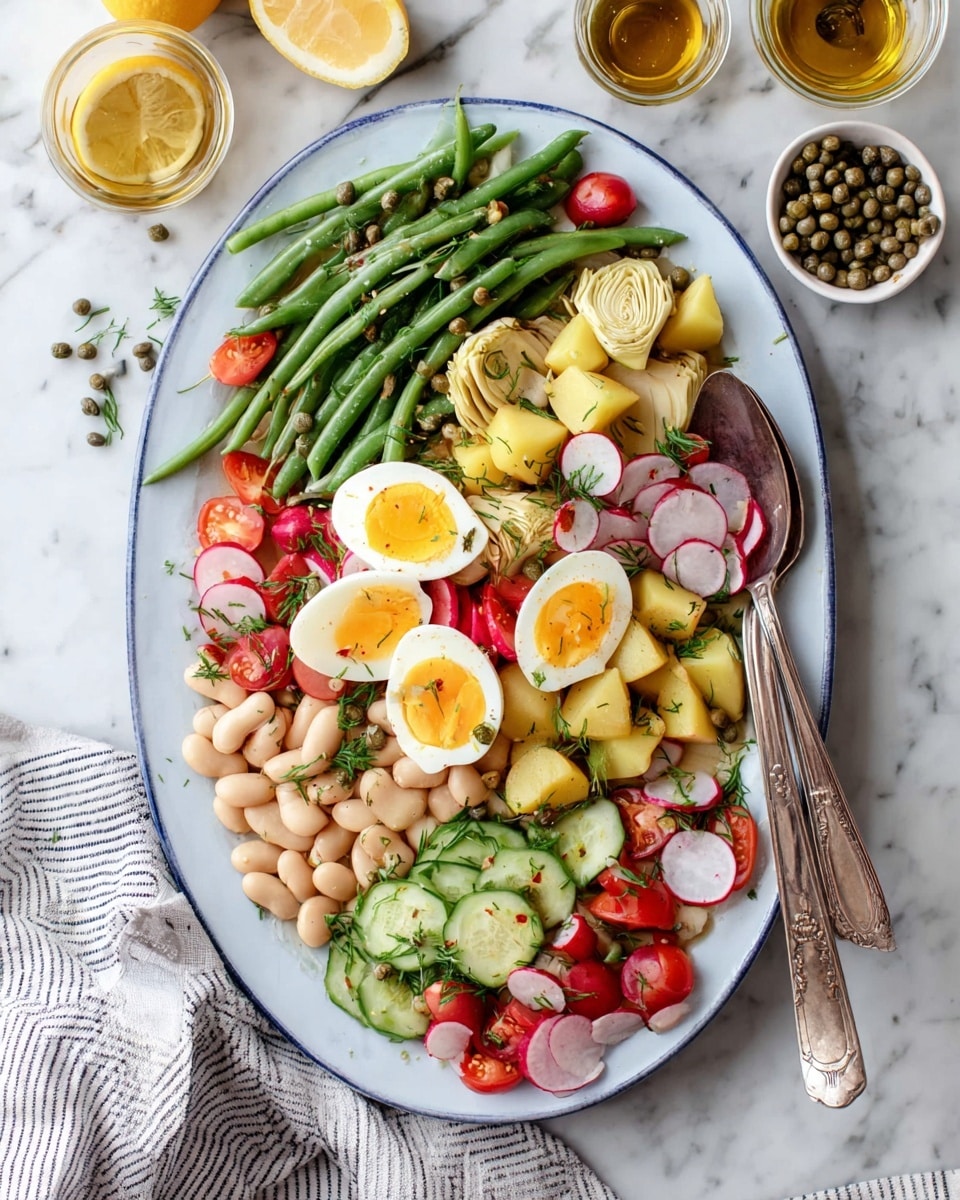 The dish is a colorful salad served on a white oval plate with a light blue rim, placed on a white marbled surface. The salad has distinct layers: a base of green beans at the top and bottom edges, pale white cannellini beans spread over half the plate on the left side, and a mix of yellow potato chunks and bright red radishes scattered throughout the middle. There are sliced green cucumbers and quartered artichoke hearts near the top center. Halved soft boiled eggs with vibrant yellow yolks are arranged near the center, surrounded by green and purple olives and halved red cherry tomatoes. The salad is sprinkled with chopped herbs and capers. On the right side of the plate, an old metal fork and serving spoon rest partially over the salad. Around the plate on the white marbled background are a halved lemon, small glass bowls with oil and capers, and a striped cloth. Photo taken with an iphone --ar 4:5 --v 7